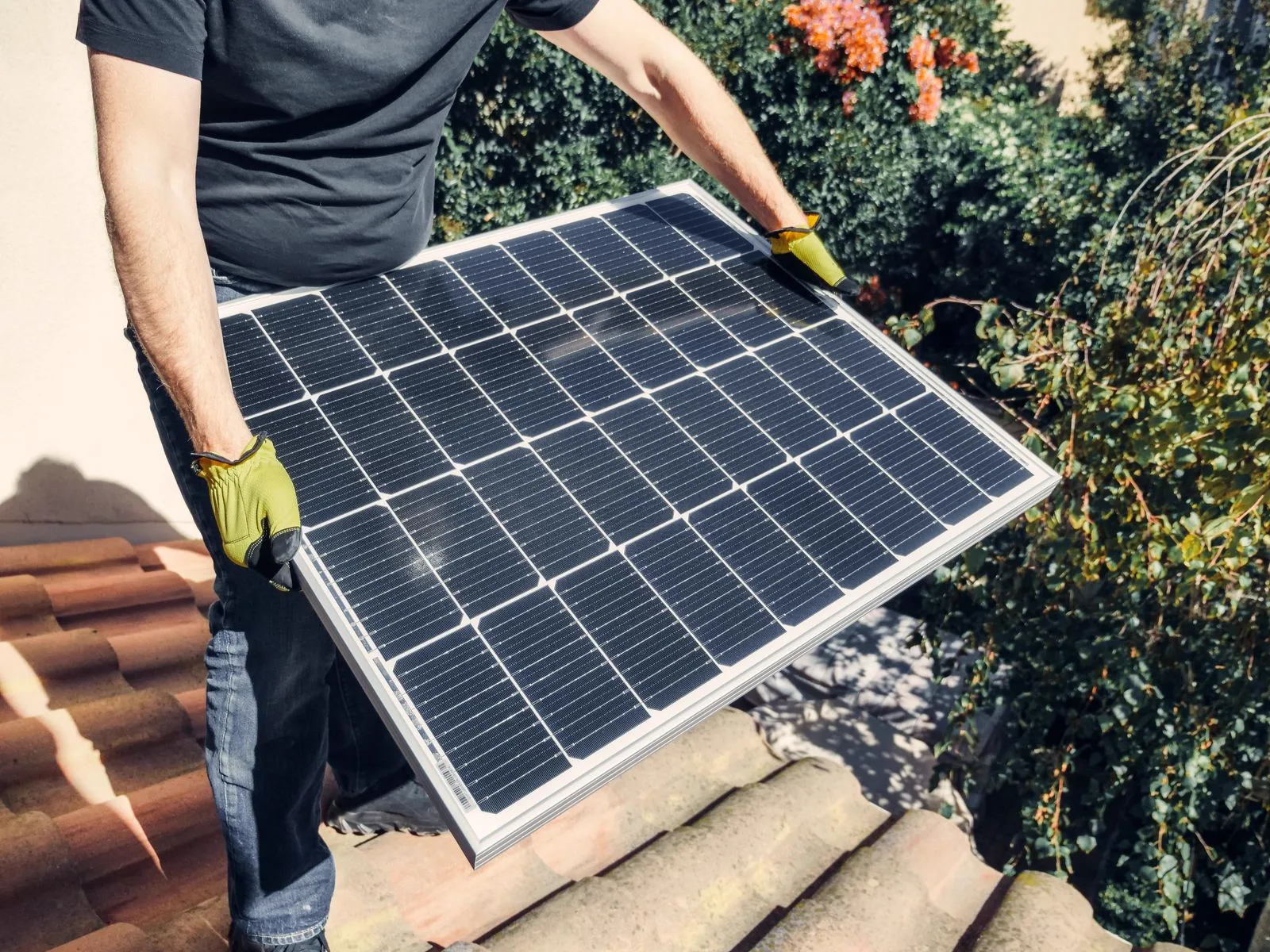 Instaler nosi solarni panel na mediteransku krovnu ploču
